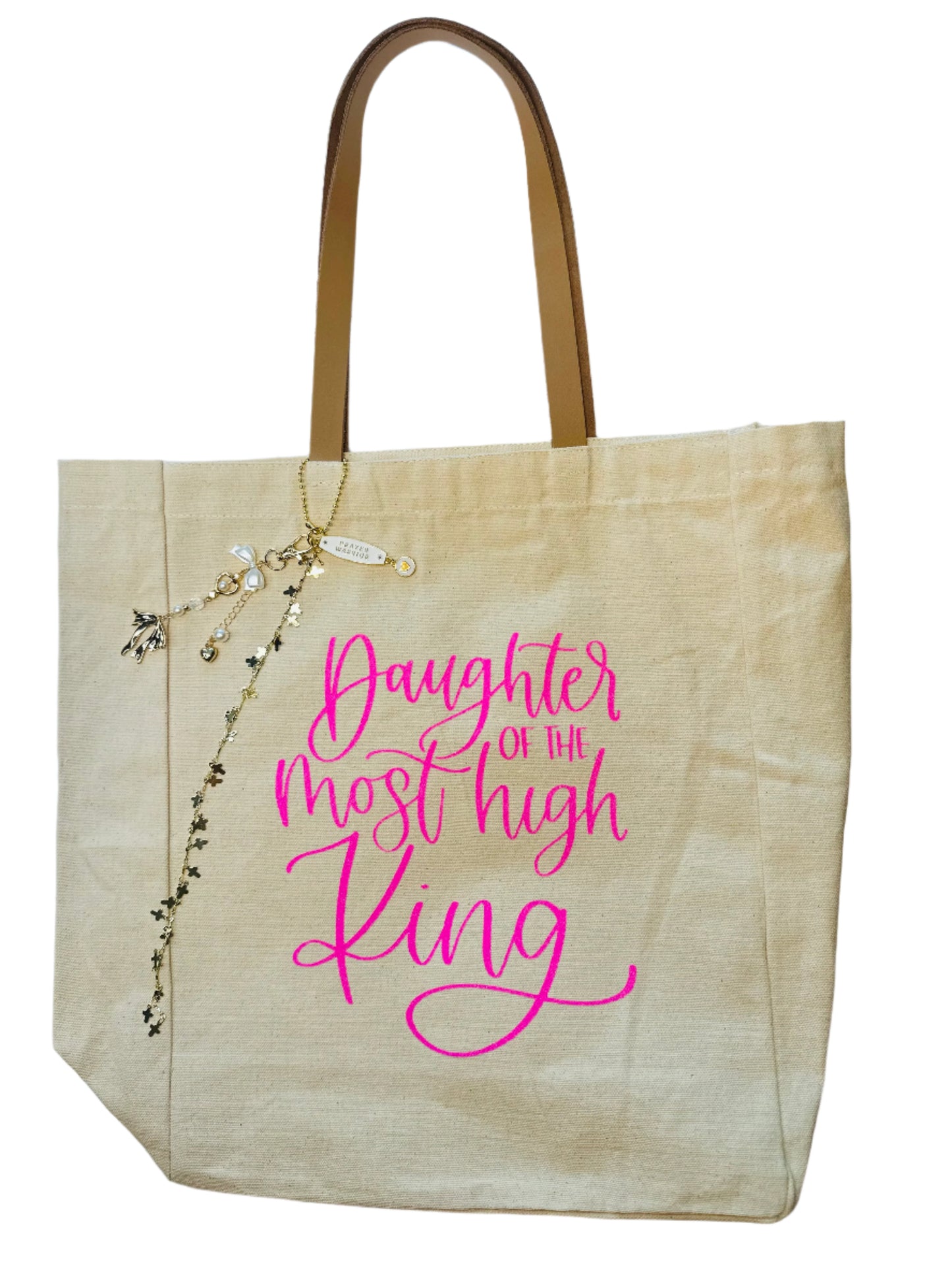 Beige tote bag with pink text 'Daughter of the most high King' on a white background